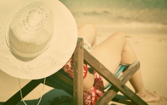 Exotic beach holiday background with white hate on beach chair