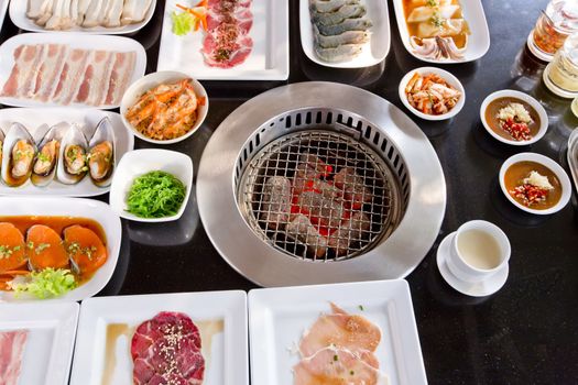 assorted meat and seafood uncooked and roaster ready to be grilled