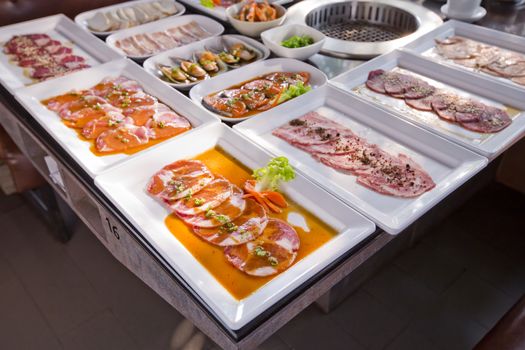 assorted meat and seafood uncooked and roaster ready to be grilled