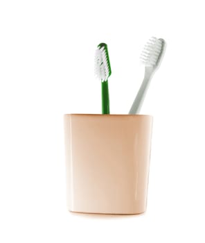 Two toothbrushes in glass