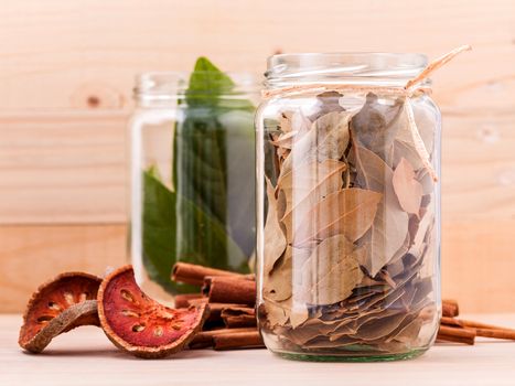 Fresh and dry bay leaves in  bowl on wooden background