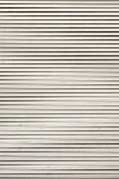 Steel shiny rolling shutter door texture with horizontal lines.