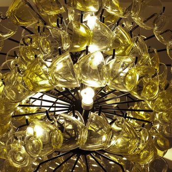 Close up Contemporary chandelier made of many yellow coffee cups.