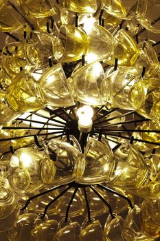 Close up Contemporary chandelier made of many yellow coffee cups.