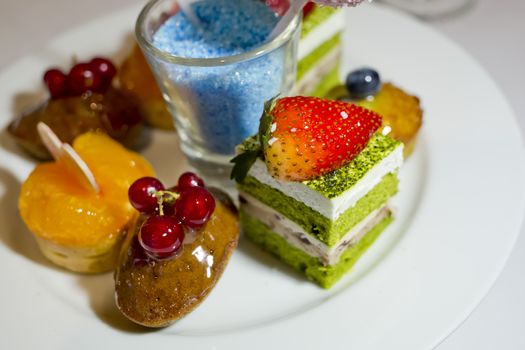 Collection of different delicious desserts and cakes in white plate