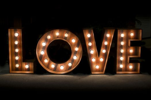 Wording Love sign with light bulb isolate on black background