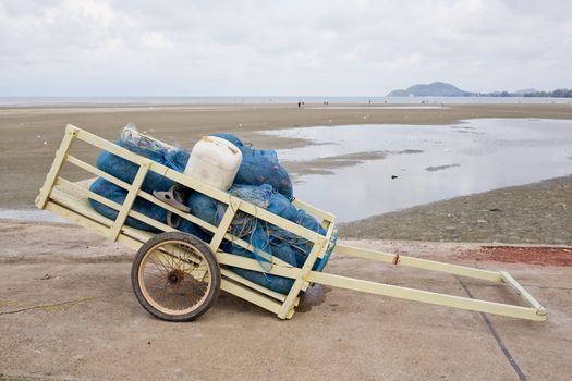 fishing net in wheelbarrow with sea