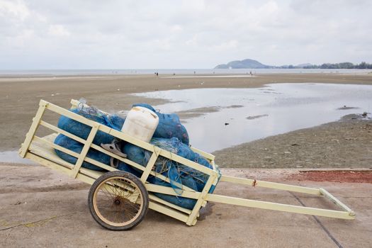 fishing net in wheelbarrow with sea