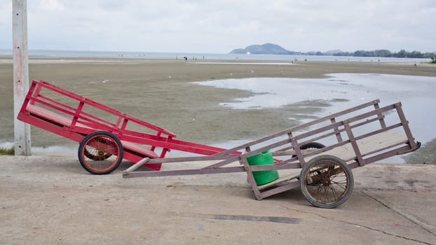 Two wheelbarrow with wooden handles on a beach