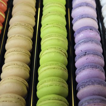 traditional french colorful macarons in a rows in a box