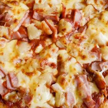 delicious hawaiian rustic style pizza made with fresh pineapples,ham and mozzarella cheese