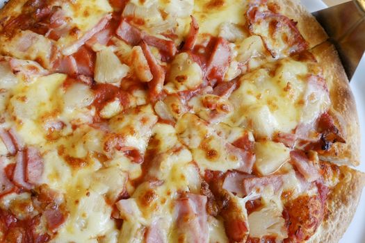 delicious hawaiian rustic style pizza made with fresh pineapples,ham and mozzarella cheese