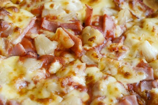 delicious hawaiian rustic style pizza made with fresh pineapples,ham and mozzarella cheese