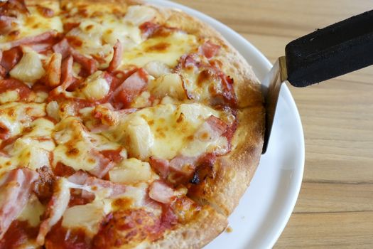 delicious hawaiian rustic style pizza made with fresh pineapples,ham and mozzarella cheese