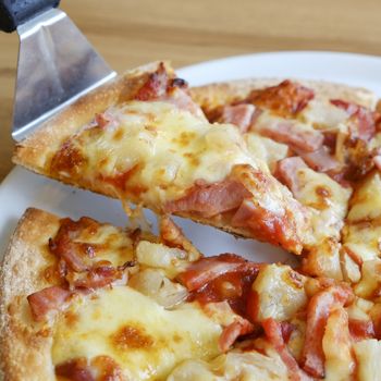 delicious hawaiian rustic style pizza made with fresh pineapples,ham and mozzarella cheese