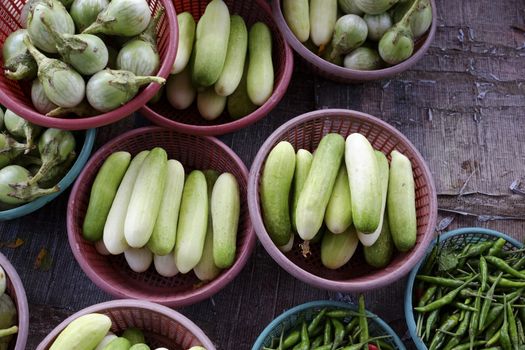 Thailand market vegetable basket selling cucumbers, chilli and Cockroach Berry.