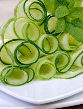 Salad cucumber ribbons twisted in rolls with mint