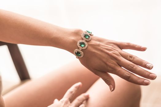wedding manicure bride in gown, emerald jewelry bracelet