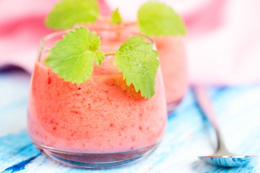 Smoothie drink with mint leafs on table, in high key