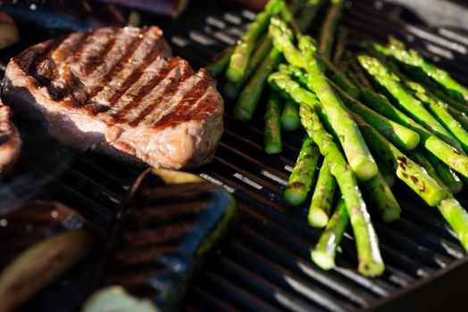 Steak and vegetables on grill at sunset, candid