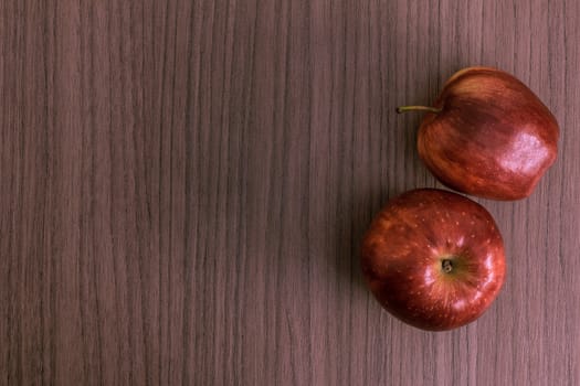 Two nice red apples over wood background