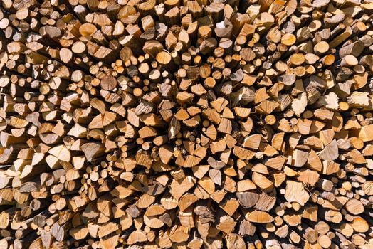 Background of dry chopped firewood logs in a pile