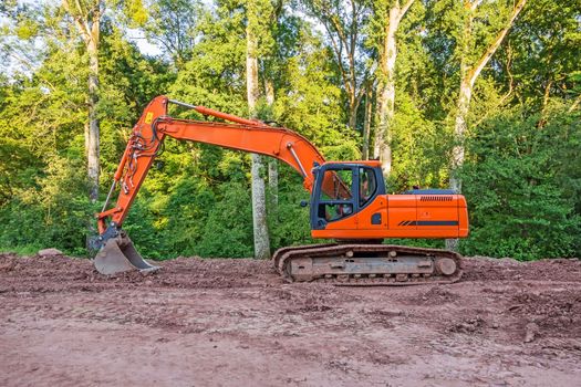 Orange crawler excavator standing in the woods