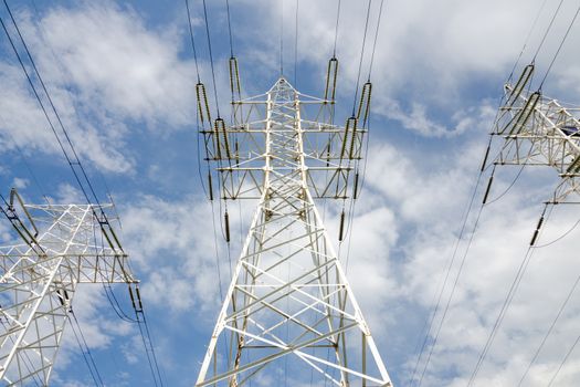 supports of high-voltage power lines against the blue sky