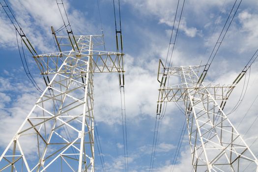 supports of high-voltage power lines against the blue sky