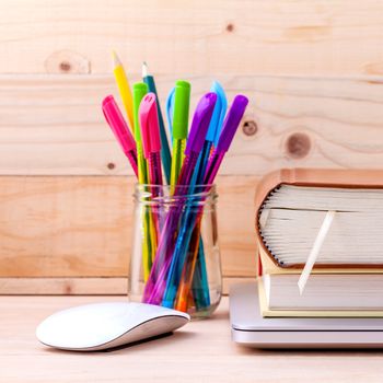 Back to school concept with school supplies laptop ,book, pen,mouse,and colored pencil on wooden table .