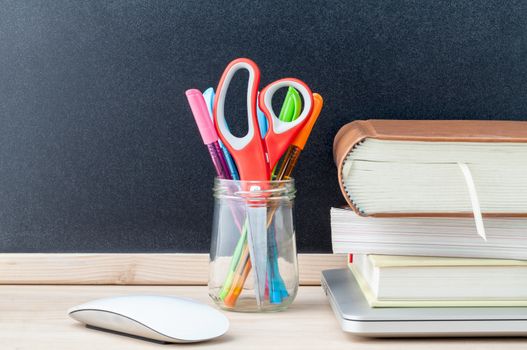 Back to school concept with school supplies laptop ,book, pen,mouse,and colored pencil on wooden table .