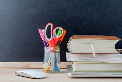 Back to school concept with school supplies laptop ,book, pen,mouse,and colored pencil on wooden table .