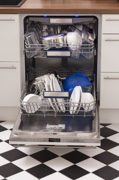 Dishwasher loades in a kitchen with clean dishes and blue light