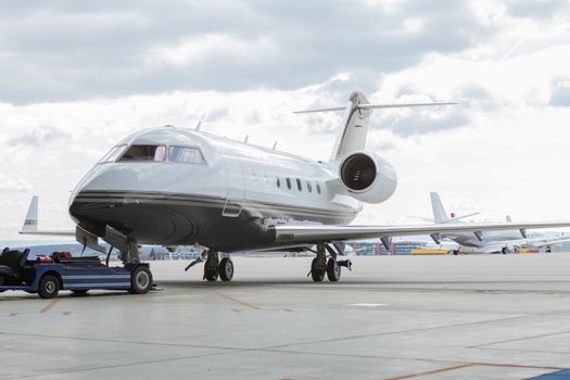 Aircraft learjet Plane in front of the Airport with cloudy sky and sun