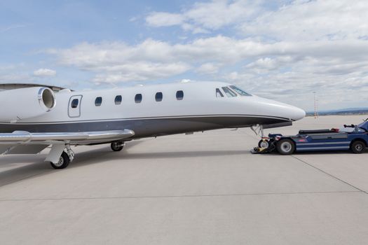 Aircraft learjet Plane in front of the Airport with cloudy sky and sun