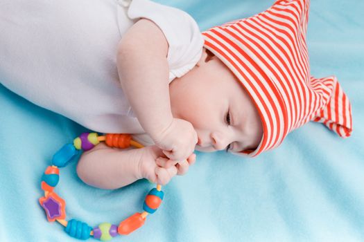 Baby in hat lying on a blue plaid