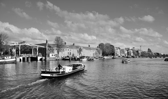 Houses and Boats on Amsterdam Canal, Amsterdam is the capital of the Netherlands (Black and White)