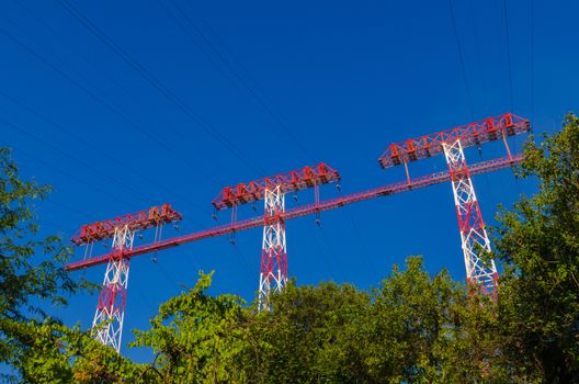 supports of high-voltage power lines against the blue sky