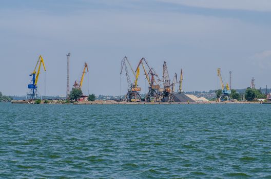 cargo port with cargo cranes on a blue sky background