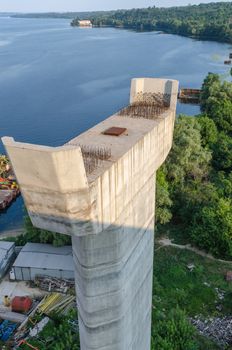 the construction of a bridge across the river with the supports, structural elements, cranes