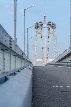 the construction of a bridge across the river with the supports, structural elements, cranes