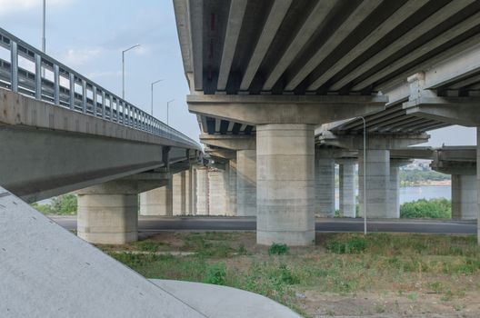 the construction of a bridge across the river with the supports, structural elements, cranes