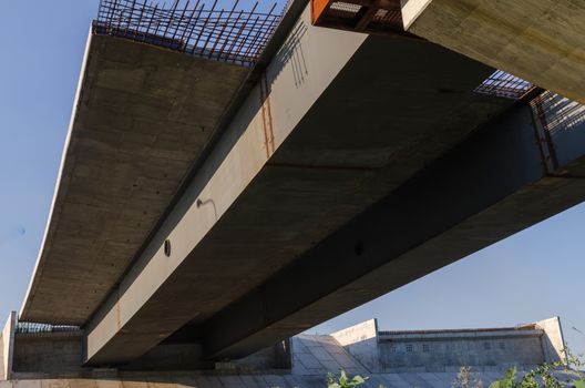 the construction of a bridge across the river with the supports, structural elements, cranes