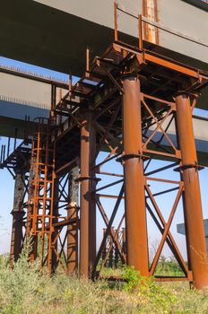 the construction of a bridge across the river with the supports, structural elements, cranes