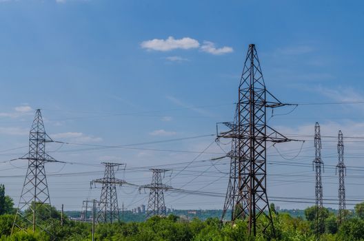 supports of high-voltage power lines against the blue sky