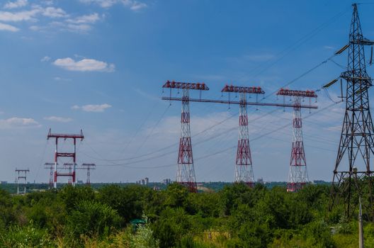 supports of high-voltage power lines against the blue sky