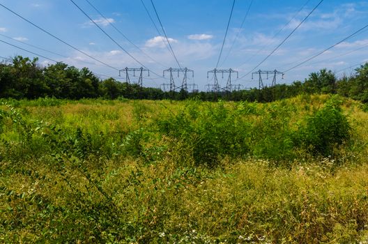 supports of high-voltage power lines against the blue sky