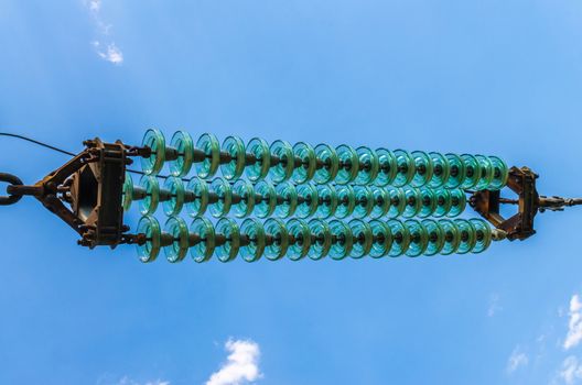 supports of high-voltage power lines against the blue sky