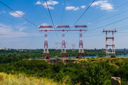 supports of high-voltage power lines against the blue sky