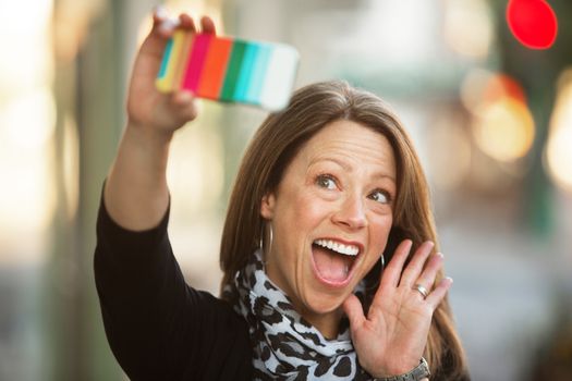 Beautiful single Caucasian woman outdoors waving at her camera